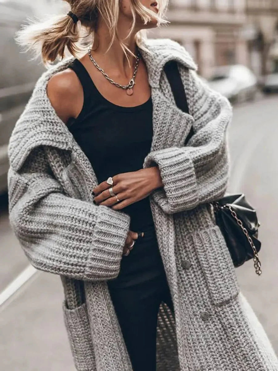 Close-up of the chunky knit texture, lapel collar and pocket detail on the Phoebe cardigan in grey
