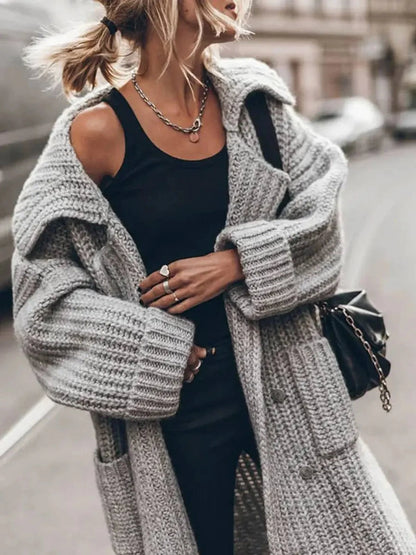 Close-up of the chunky knit texture, lapel collar and pocket detail on the Phoebe cardigan in grey